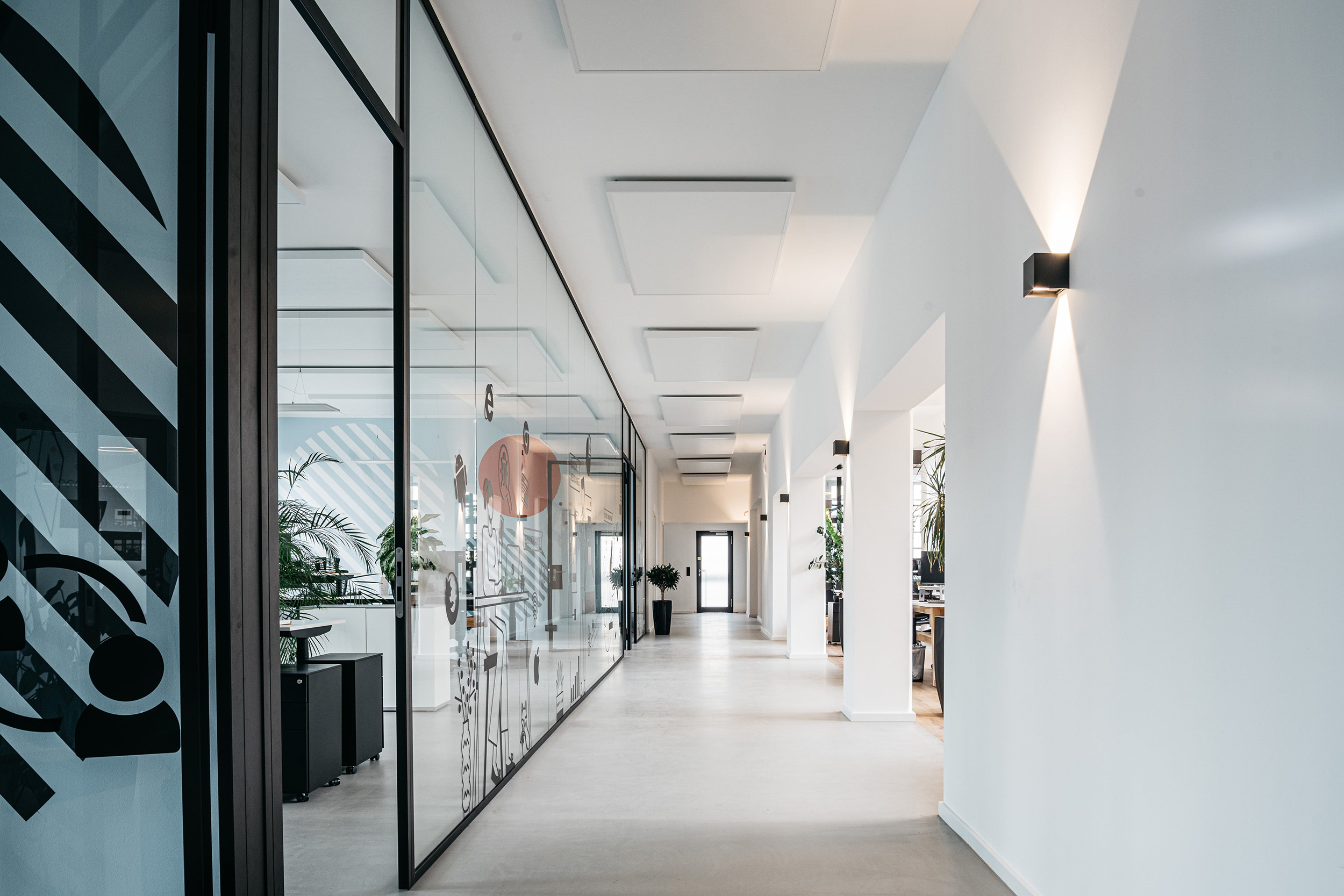 Lichtdurchfluteter Flur im pace-IT Büro Köln mit stilvollen Glaselementen, modernen Leuchten und offener Arbeitsatmosphäre