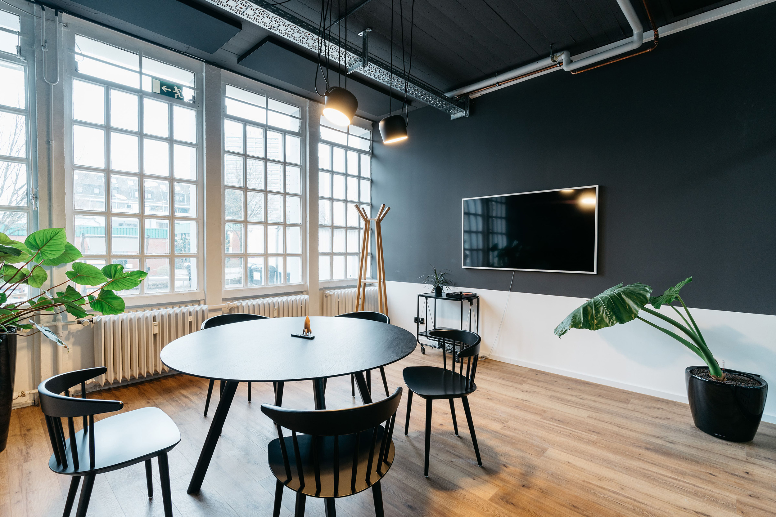 Moderner Meetingraum bei pace-IT Köln mit Rundtisch, Flatscreen und großen Fenstern für inspirierende Teamgespräche